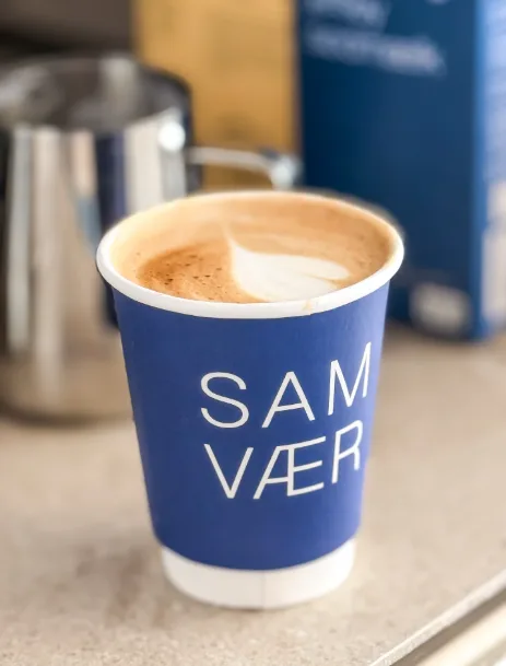 Caffè latte i en blå Samvær-kop